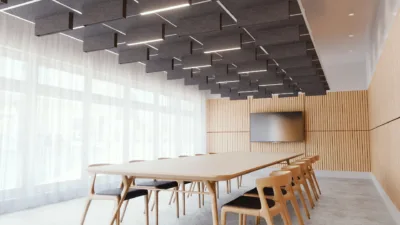 Acoustic Slot Lighting above a long conference table with a tv on the wall at the end of the room.