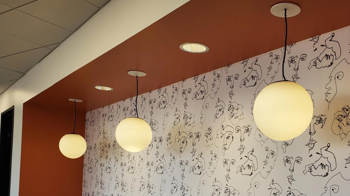 pendant lights with a patterned wallpaper behind on the wall