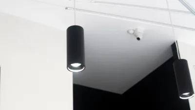 Black cylinder lighting hanging from a ceiling