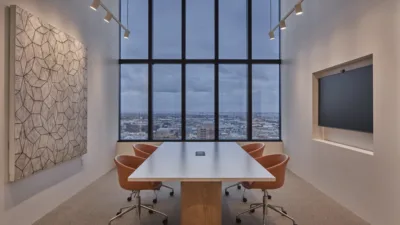 Conference room with large window and track lighting along both side walls to highlight the artwork.